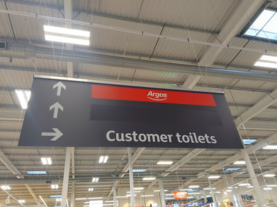 A direction sign indicating that Argos is straight-on and the customer toilets are to the right